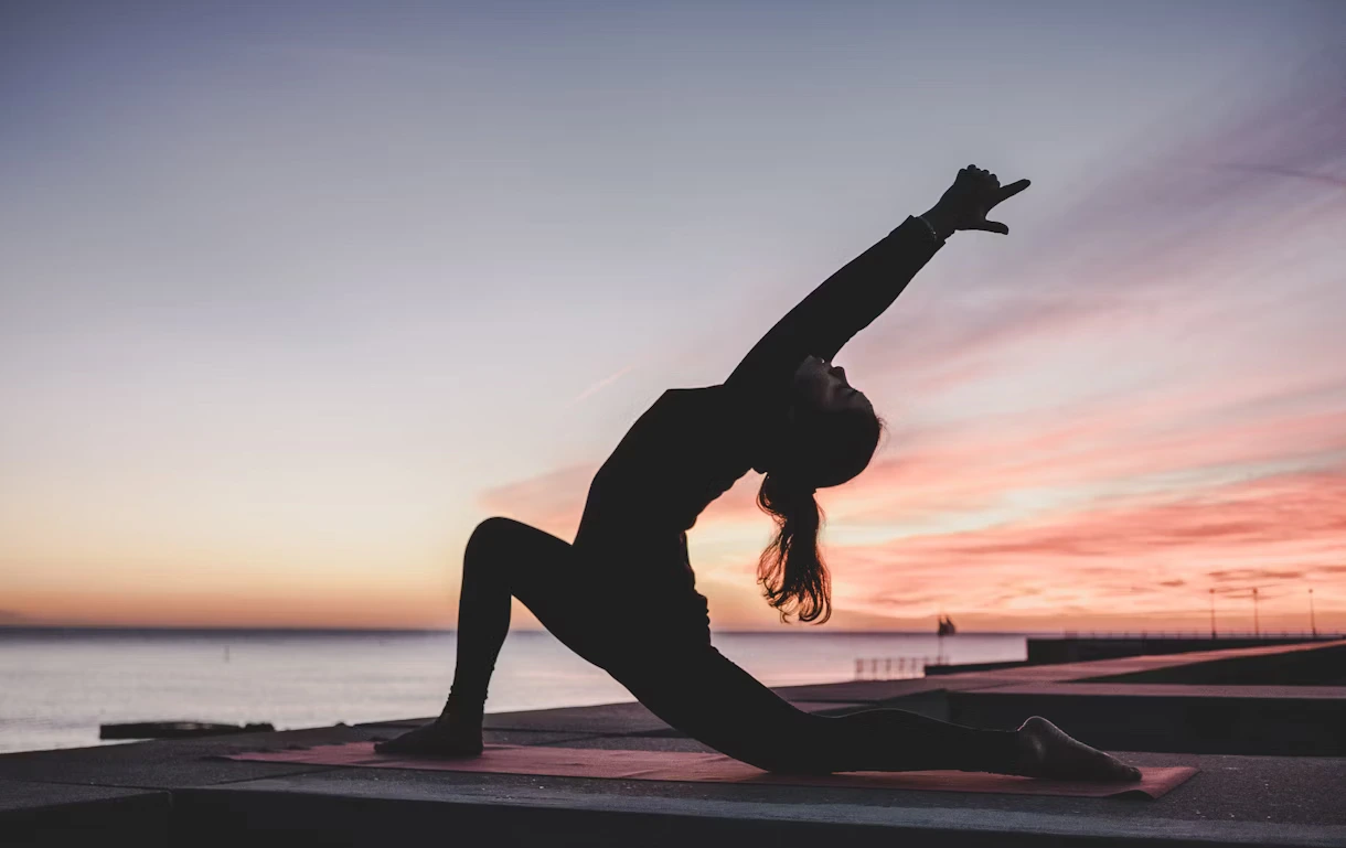 Un instructor de yoga ayudando a un alumno